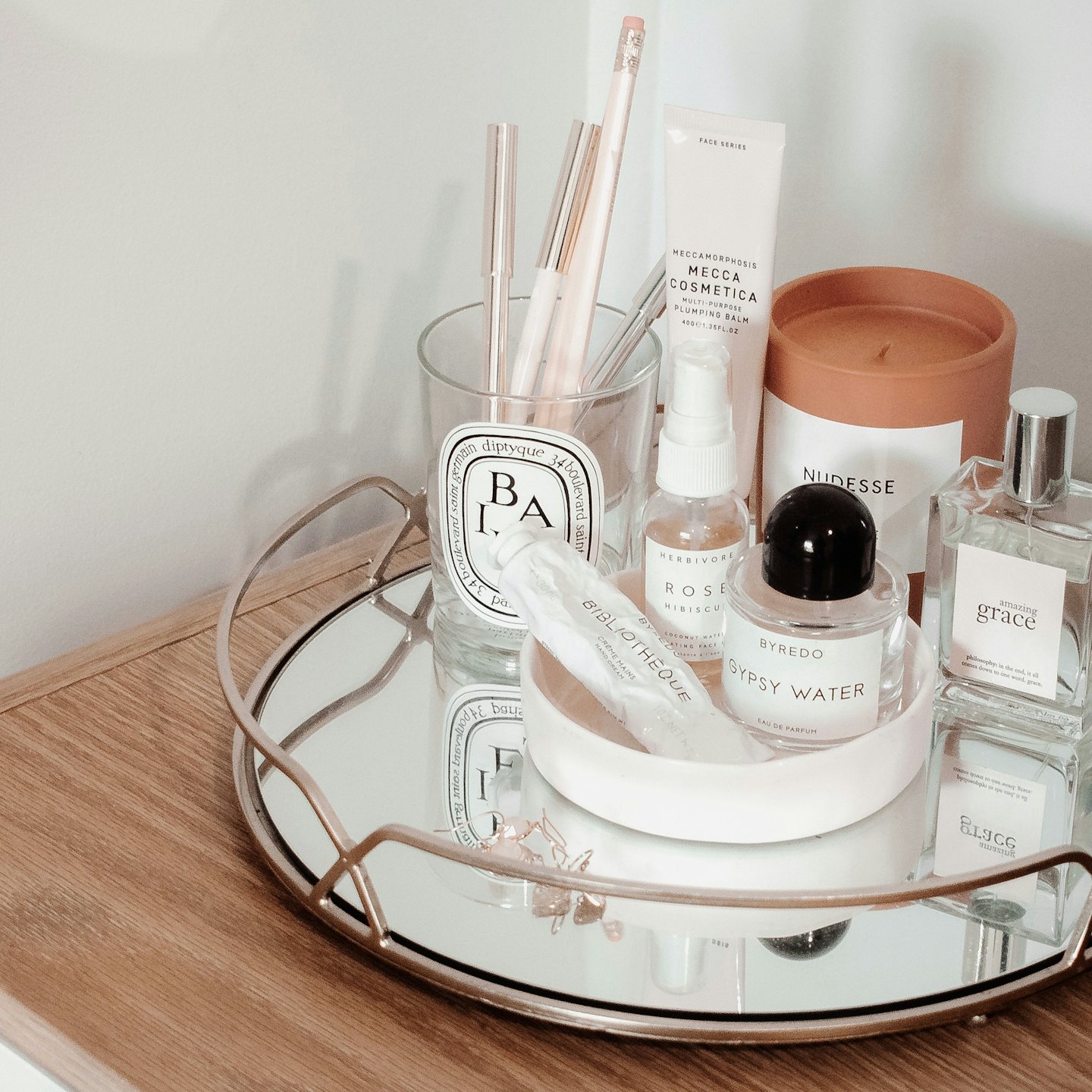 Luxury beauty products arranged on a mirrored tray.